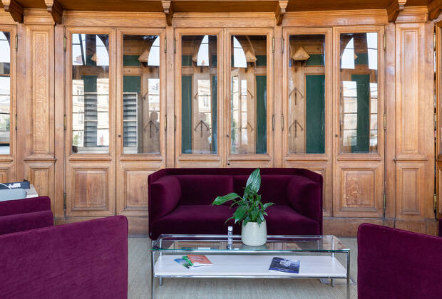 Im Loungebereich lädt das Sofa „Crest“ in burgunderrotem Samt zum Entspannen ein. (Bild: Kinnarps)